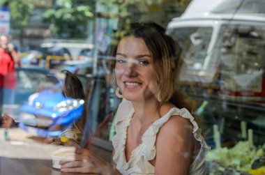 Gelato dondurma cam kafe arkasında genç çekici kız yiyor