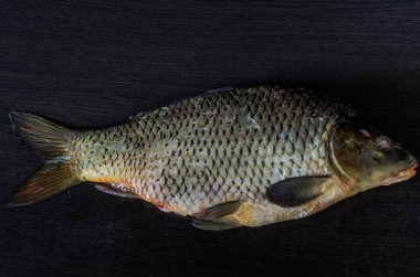 Siyah bir zemin üzerine soyulmuş balık sazan