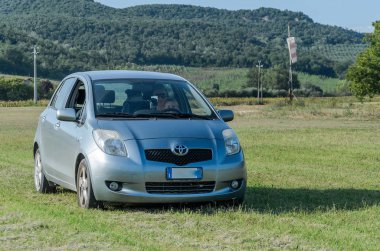 Roma, İtalya - Ağustos 2018: gümüş bir araba küçük bebek kız. Toyota Yaris ve annesi alanın karşısındaki ilerliyorsunuz