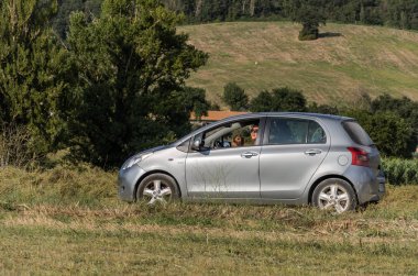 Roma, İtalya - Ağustos 2018: gümüş bir araba küçük bebek kız. Toyota Yaris ve annesi alanın karşısındaki ilerliyorsunuz