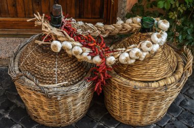Sarımsak ve biber ile asma ile örgülü iki büyük cam şarap şişe