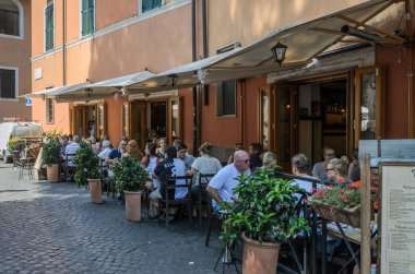 Roma, İtalya - Ağustos 2018: Turist sıcak güneşli bir günde bir İtalyan restoranı terasta oturun