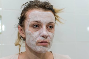 Genç kız kendini beyaz bir kozmetik maske yapar