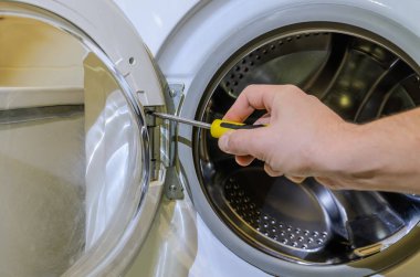 Master çamaşır makinesi bir tornavida ile onarır.