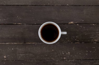 Beyaz fincan kahve masada eski ahşap, üstten görünüm