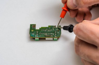 Ana mühendis sınar ve miniyonga multimetre ile onarır