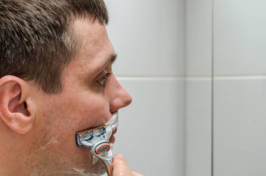 Adam tıraş jilet ve tıraş köpüğü banyoda