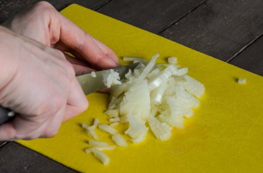 Bir kesme tahtası üzerinde dilim soğan yemek