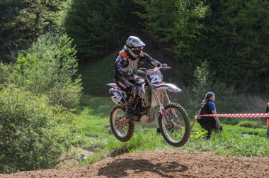 Lviv, Ukrayna - Mayıs, 2019: Atlet motosiklet yarışçısı bir motokros pistinde enduro motosiklete biniyor ve atlıyor