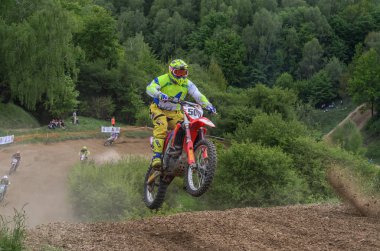 Lviv, Ukrayna - Mayıs, 2019: Atlet motosiklet yarışçısı bir motokros pistinde enduro motosiklete biniyor ve atlıyor