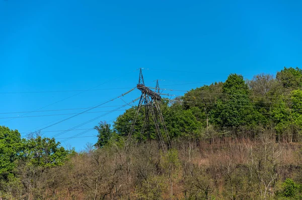 Wysokonapięciowe Pole Zasilania Górze Pośród Drzew — Zdjęcie stockowe