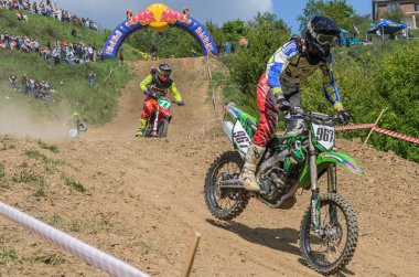 Lviv, Ukrayna - Mayıs, 2019: Atlet motosiklet yarışçısı bir motokros pistinde enduro motosiklete biniyor ve atlıyor