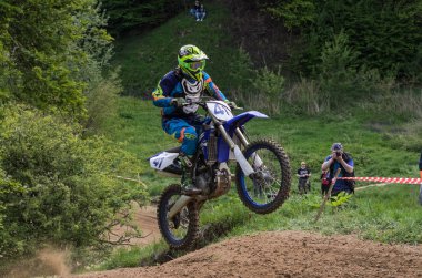 Lviv, Ukrayna - Mayıs, 2019: Atlet motosiklet yarışçısı bir motokros pistinde enduro motosiklete biniyor ve atlıyor