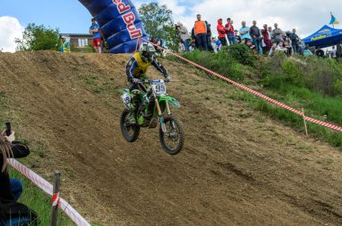 Lviv, Ukrayna - Mayıs, 2019: Atlet motosiklet yarışçısı bir motokros pistinde enduro motosiklete biniyor ve atlıyor