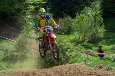 Lviv, Ukrayna - Mayıs, 2019: Atlet motosiklet yarışçısı bir motokros pistinde enduro motosiklete biniyor ve atlıyor