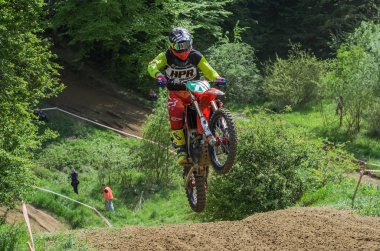 Lviv, Ukrayna - Mayıs, 2019: Atlet motosiklet yarışçısı bir motokros pistinde enduro motosiklete biniyor ve atlıyor