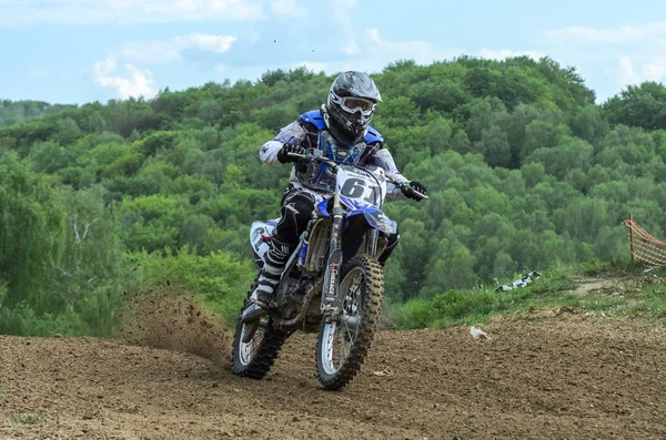 Lviv, Ukrayna - Mayıs, 2019: Atlet motosiklet yarışçısı bir motokros pistinde enduro motosiklete biniyor ve atlıyor