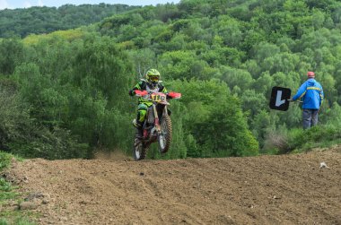 Lviv, Ukrayna - Mayıs, 2019: Atlet motosiklet yarışçısı bir motokros pistinde enduro motosiklete biniyor ve atlıyor