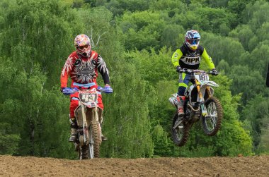 Lviv, Ukrayna - Mayıs, 2019: Atlet motosiklet yarışçısı bir motokros pistinde enduro motosiklete biniyor ve atlıyor