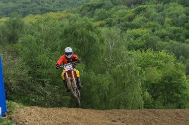 Lviv, Ukrayna - Mayıs, 2019: Atlet motosiklet yarışçısı bir motokros pistinde enduro motosiklete biniyor ve atlıyor