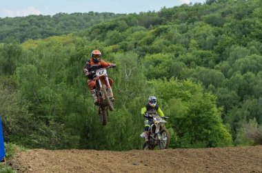 Lviv, Ukrayna - Mayıs, 2019: Atlet motosiklet yarışçısı bir motokros pistinde enduro motosiklete biniyor ve atlıyor