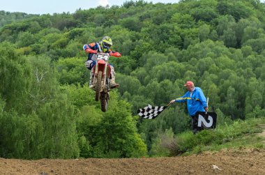 Lviv, Ukrayna - Mayıs, 2019: Atlet motosiklet yarışçısı bir motokros pistinde enduro motosiklete biniyor ve atlıyor