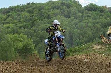 Lviv, Ukrayna - Mayıs, 2019: Atlet motosiklet yarışçısı bir motokros pistinde enduro motosiklete biniyor ve atlıyor