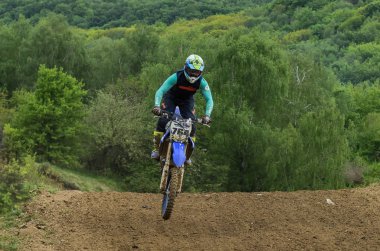 Lviv, Ukrayna - Mayıs, 2019: Atlet motosiklet yarışçısı bir motokros pistinde enduro motosiklete biniyor ve atlıyor