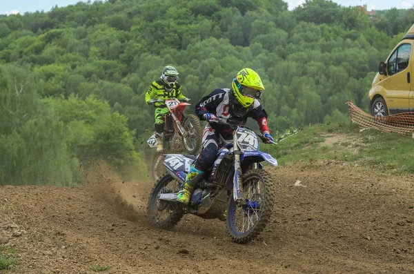 Lviv, Ukrayna - Mayıs, 2019: Atlet motosiklet yarışçısı bir motokros pistinde enduro motosiklete biniyor ve atlıyor