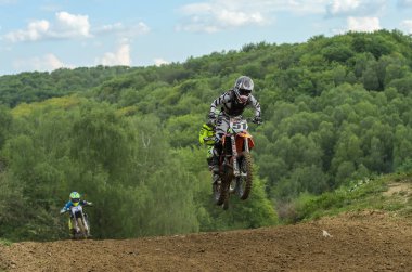 Lviv, Ukrayna - Mayıs, 2019: Atlet motosiklet yarışçısı bir motokros pistinde enduro motosiklete biniyor ve atlıyor
