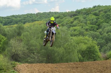 Lviv, Ukrayna - Mayıs, 2019: Atlet motosiklet yarışçısı bir motokros pistinde enduro motosiklete biniyor ve atlıyor