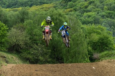 Lviv, Ukrayna - Mayıs, 2019: Atlet motosiklet yarışçısı bir motokros pistinde enduro motosiklete biniyor ve atlıyor