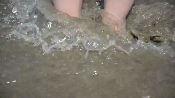 被海浪冲刷的沙滩上妇女的腿 — 图库视频影像