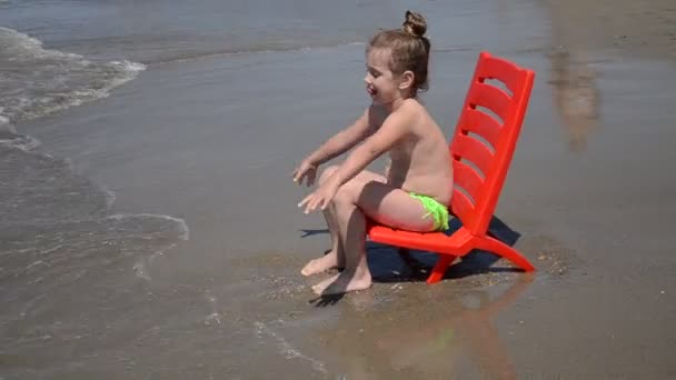 Bambina Affascinante Seduta Una Sedia Riva Mare Una Spiaggia Sabbia — Video Stock