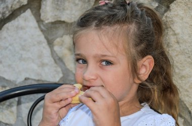 Küçük sevimli kız çocuk bir pasta yiyor