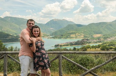 Lago del Turano dağ gölünün arka planında aşık genç çift