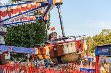 Roma, İtalya - Temmuz 2019: Bir lunaparkta atlıkarıncaya binen küçük sevimli kız