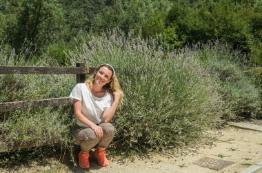 Güneşli bir günde lavanta çalıların çiçekleri yanında genç büyüleyici kız