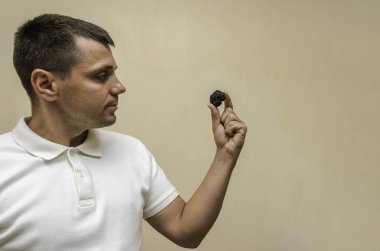 Genç bir adam, bir aşçı, elinde siyah mantar mantarları var.