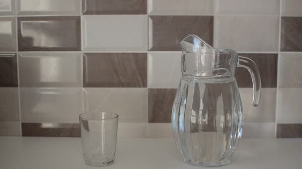 Ein Mann Gießt Reines Wasser Aus Einer Glaskaraffe Einen Glasbecher — Stockvideo