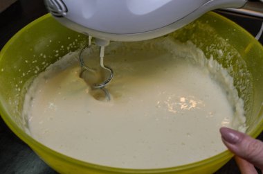 Tabaktaki elektrikli mikser hamuru kamçılıyor.