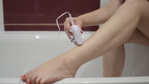 Женщина Эпилирует Ноги Электрическим Эпилятором — стоковое видео