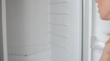 Hizmetçi içerideki buzdolabını temizliyor.