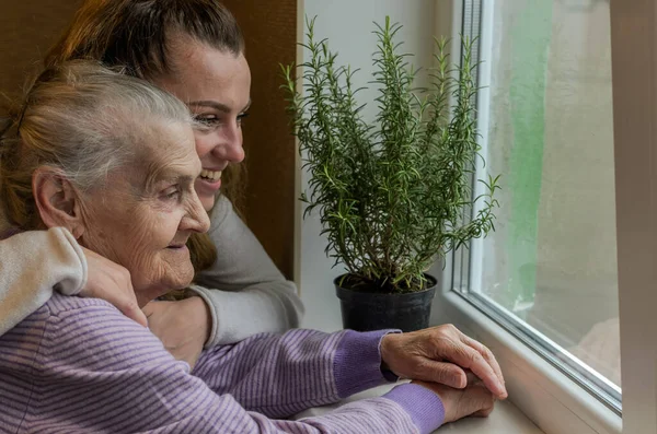 Elderly Woman Grandmother Looks Out Window Granddaughter Approaches Her Hugs Royalty Free Stock Images