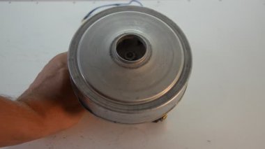 Usta elektrik süpürgesinin elektrik motorunu tamir ediyor.