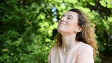 Yaz parkında genç ve çekici bir kız. Mutlu gülüyor.