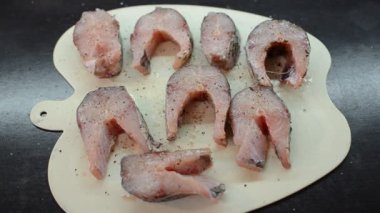 Limon suyuyla sulanmış kesme tahtasındaki çiğ balık bifteği.