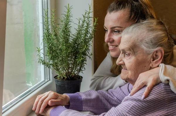 Elderly Woman Grandmother Looks Out Window Granddaughter Approaches Her Hugs Stock Photo
