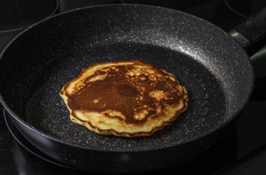 İndüksiyon ocağında tavada krep kızartır.