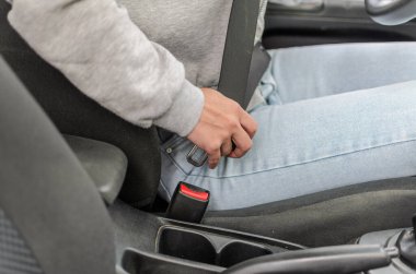 Arabada emniyet kemeri takan genç bir kadın.